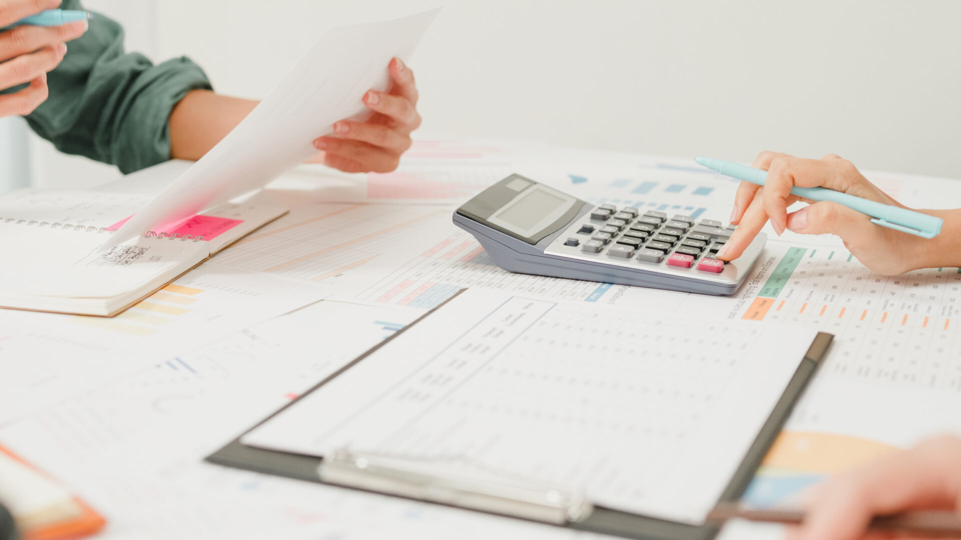Team discussing documents with calculator