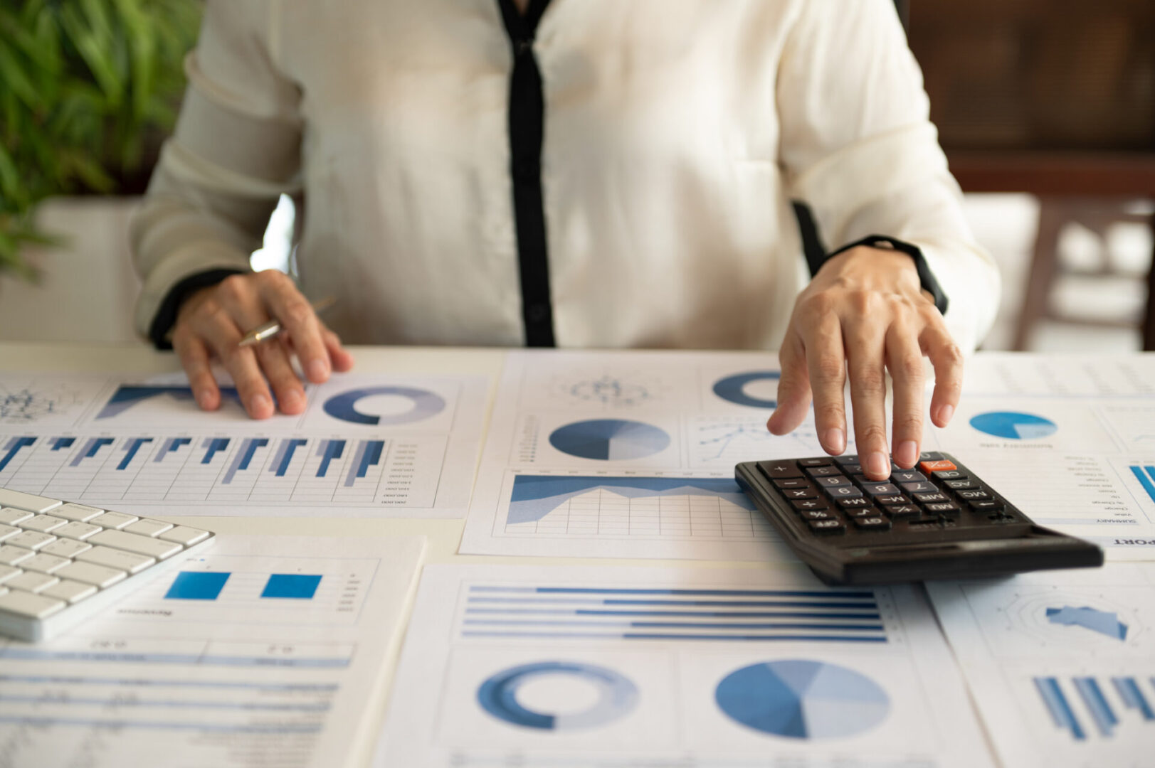 Hands using calculator on financial documents
