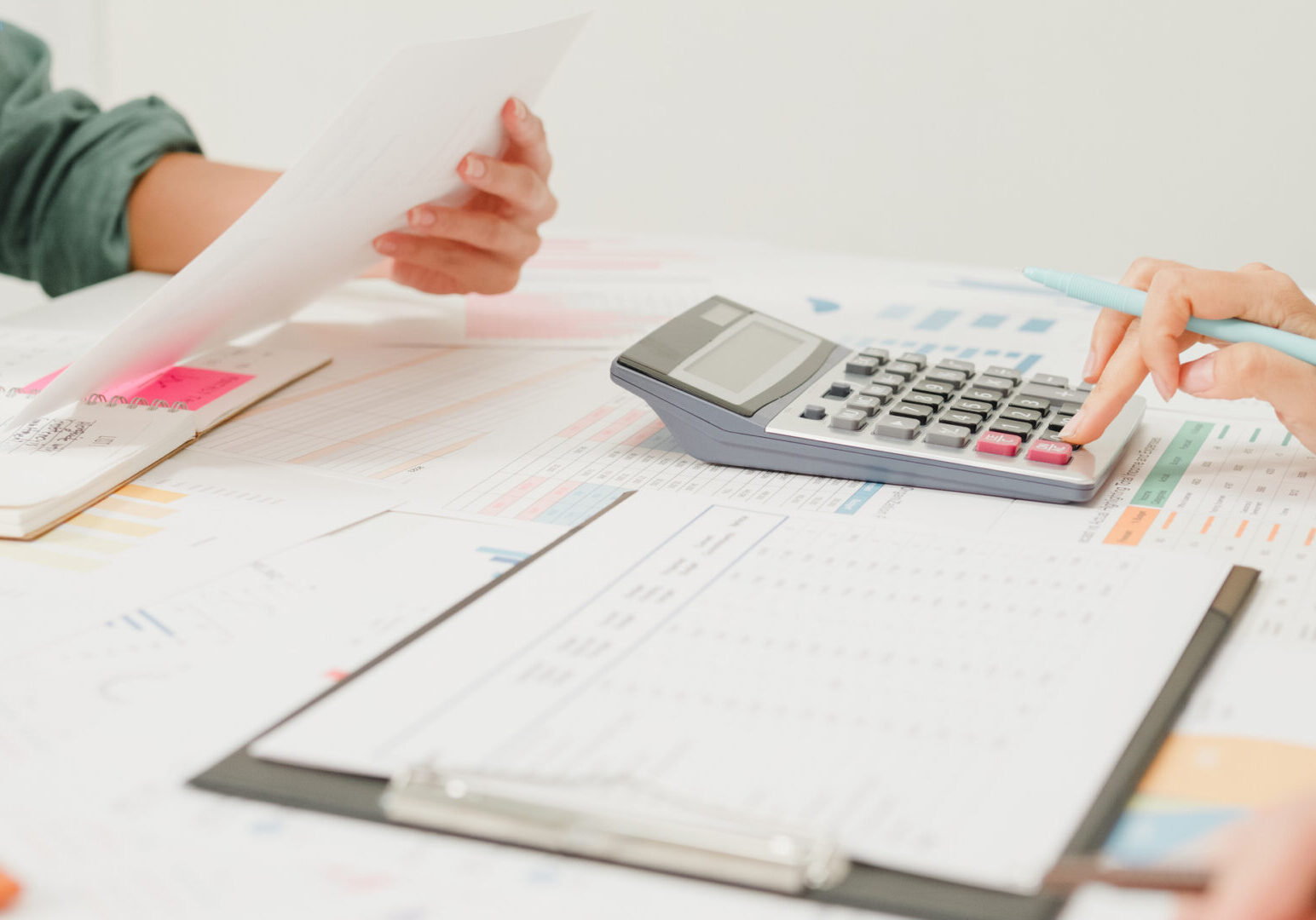 Team discussing documents with calculator